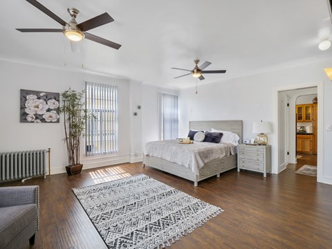 A bedroom with a large bed and a ceiling fan.