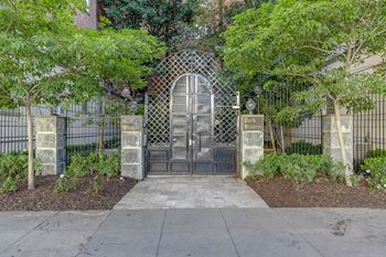 A gated entrance with a metal gate and a sign that says "Emergency Exit".