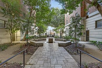 A courtyard with a brick pathway and trees.