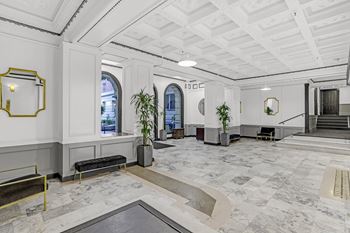 A spacious lobby with marble floors and a staircase.