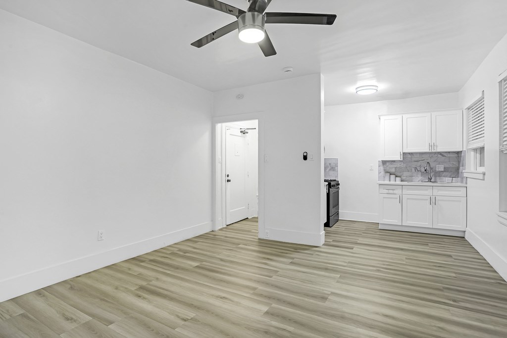 A room with a ceiling fan and lighting fixture.