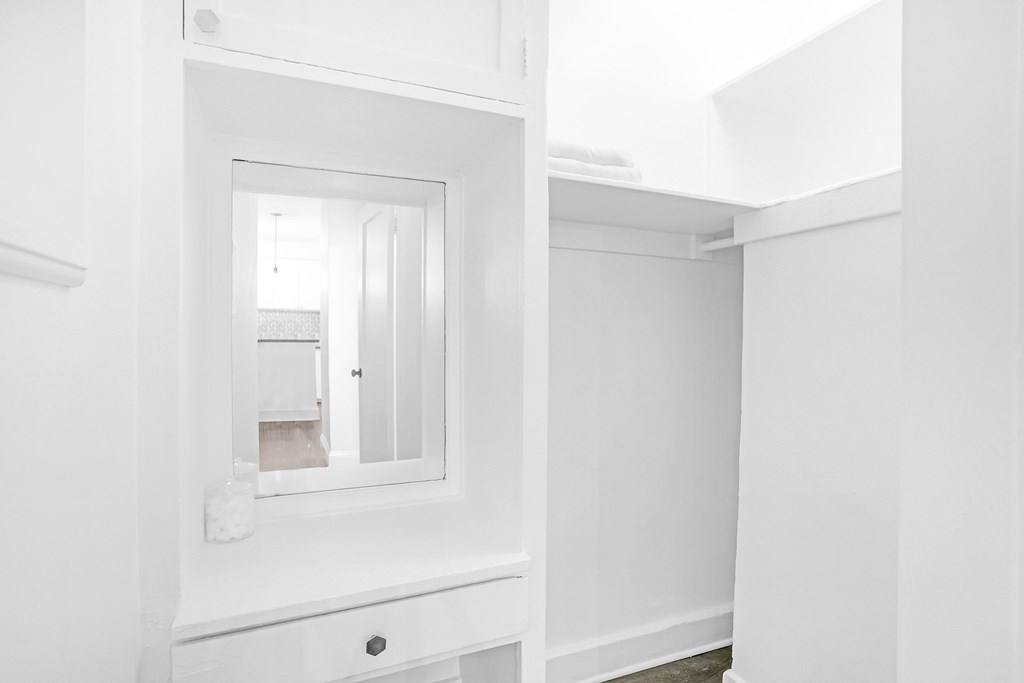 A white bathroom with a mirror and a sink.