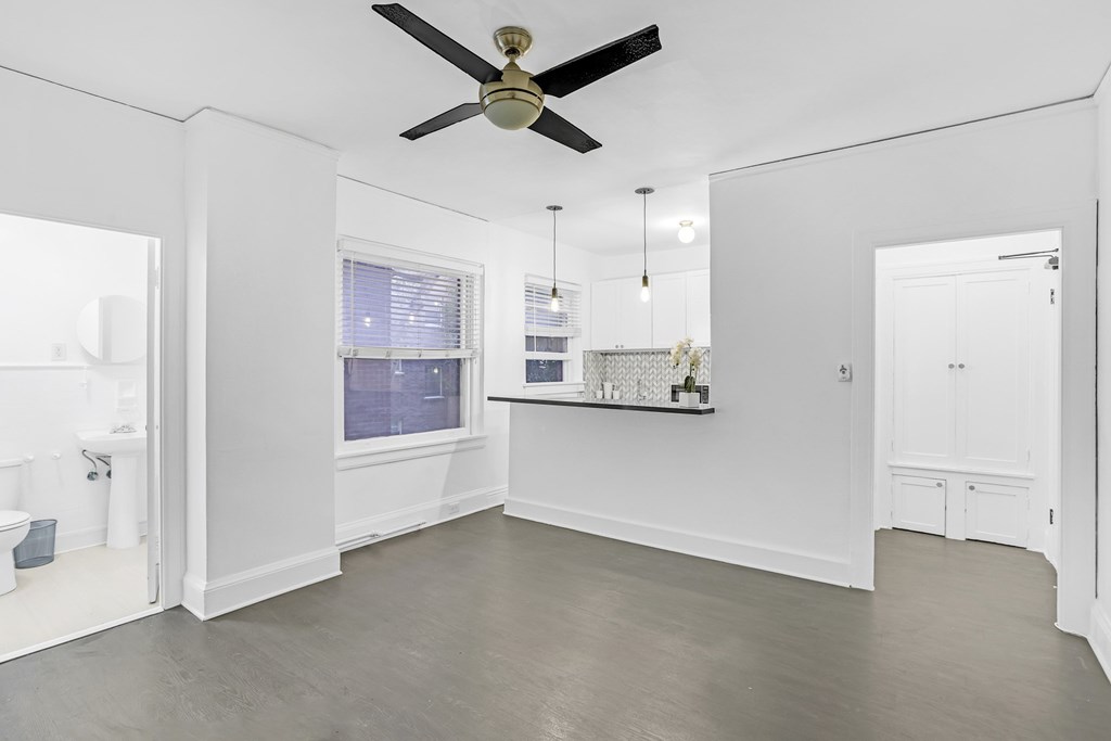 A spacious room with a ceiling fan and a window.