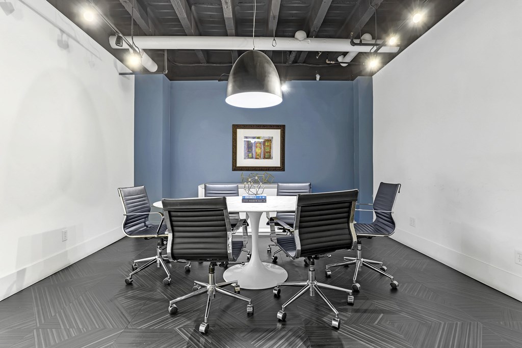 A conference room with a white table and chairs.