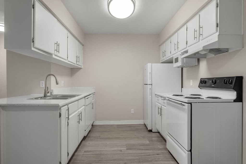 a white kitchen with white appliances and white cabinets