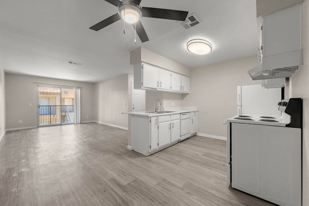 an empty kitchen and living room with a ceiling fan