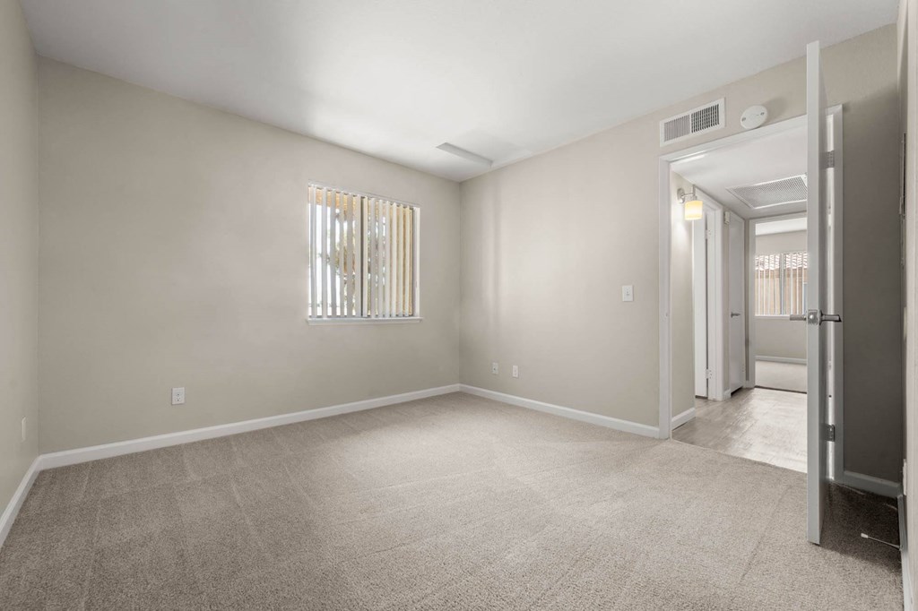 a empty room with a door to a hallway and a closet