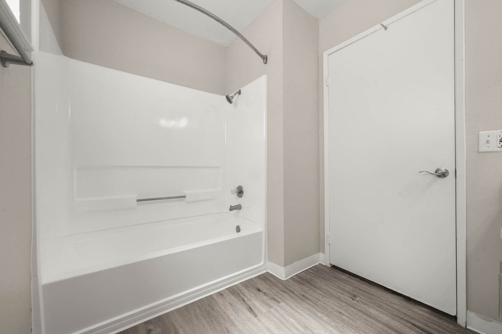 a white bathroom with a tub and a shower in it