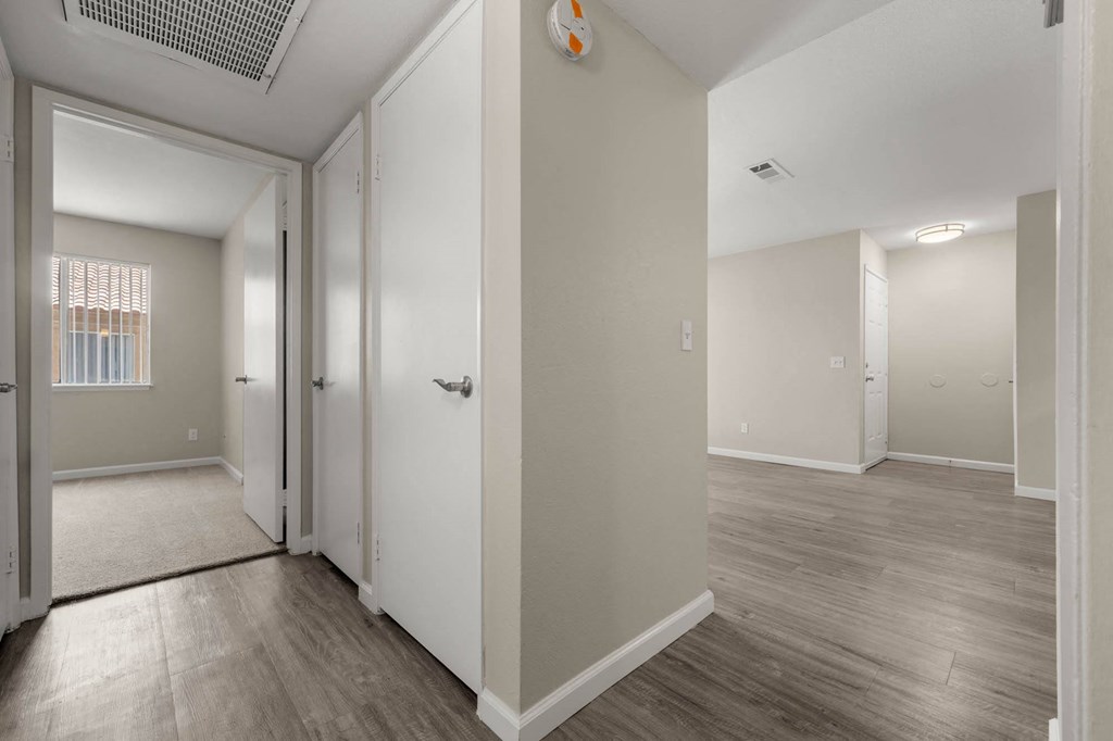 a renovated living room with white walls and wood floors