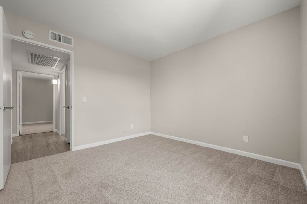 an empty living room with white walls and carpet