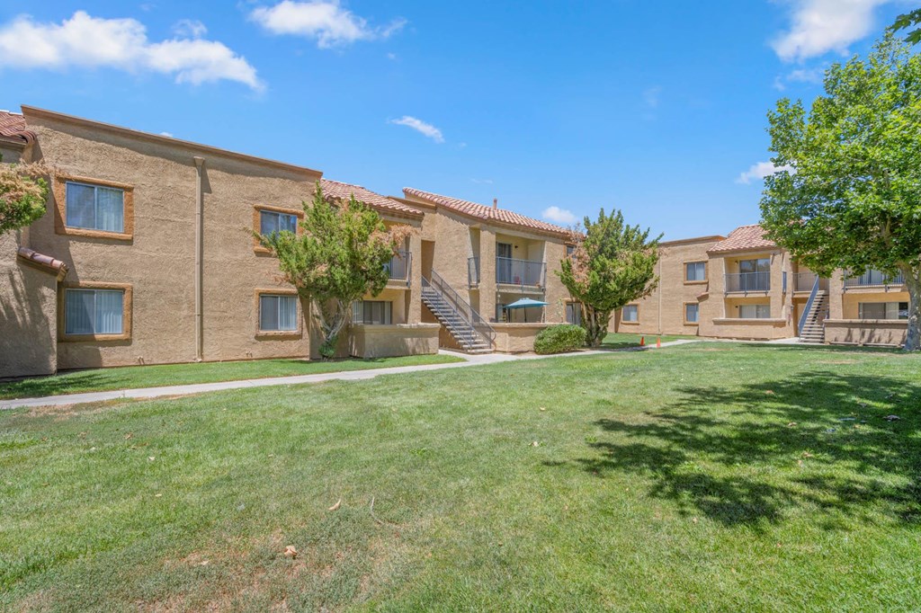 a row of brick apartments with grass and trees