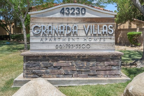 a stone monument with a sign for grandpa villas apartments
