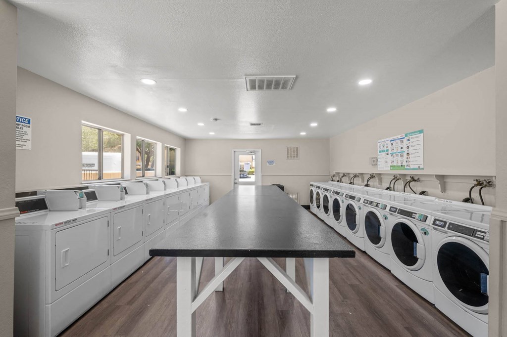 a laundry room with washes and dryers and a table