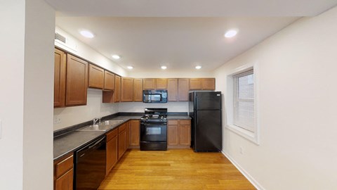 a kitchen with wooden cabinets and a black refrigerator
