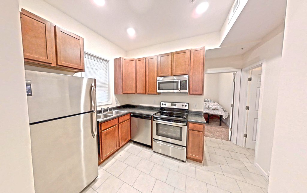 a kitchen with wooden cabinets and stainless steel appliances