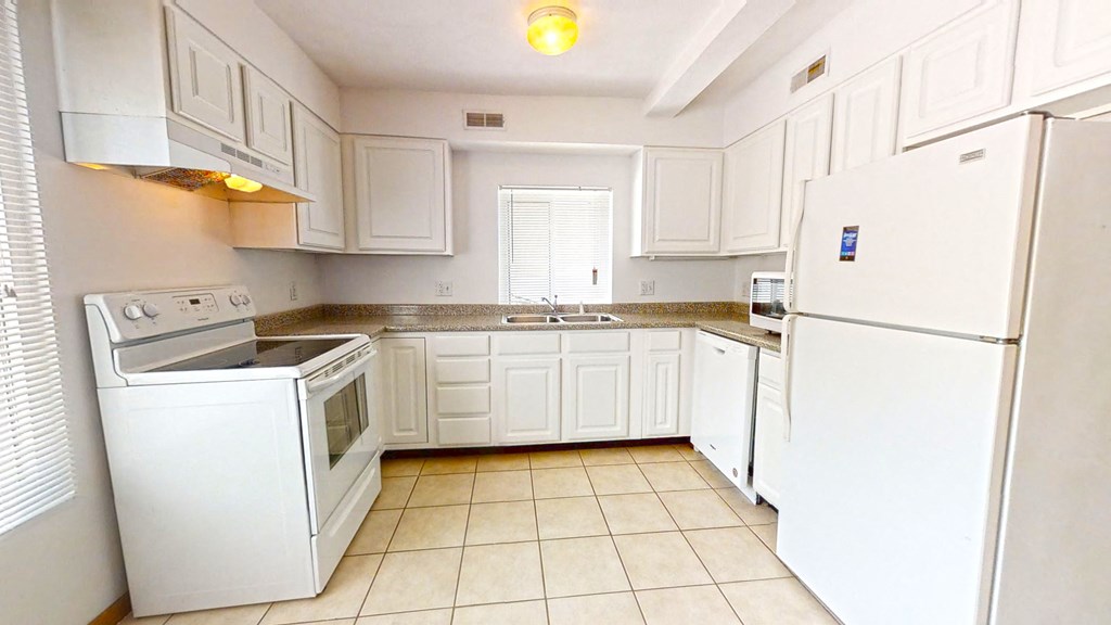 a kitchen with white cabinets and white appliances