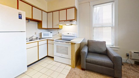 a kitchen with a chair and a sink and a refrigerator