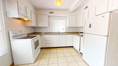 a kitchen with white appliances and white cabinets