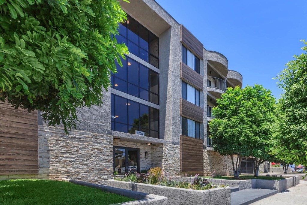 A modern building with a stone facade and large windows at Lafayette Apartments, Los Angeles