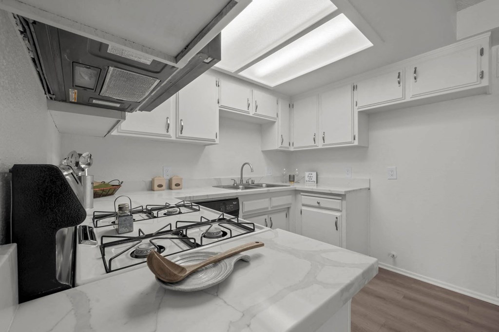 a kitchen with white cabinets and a stove top oven