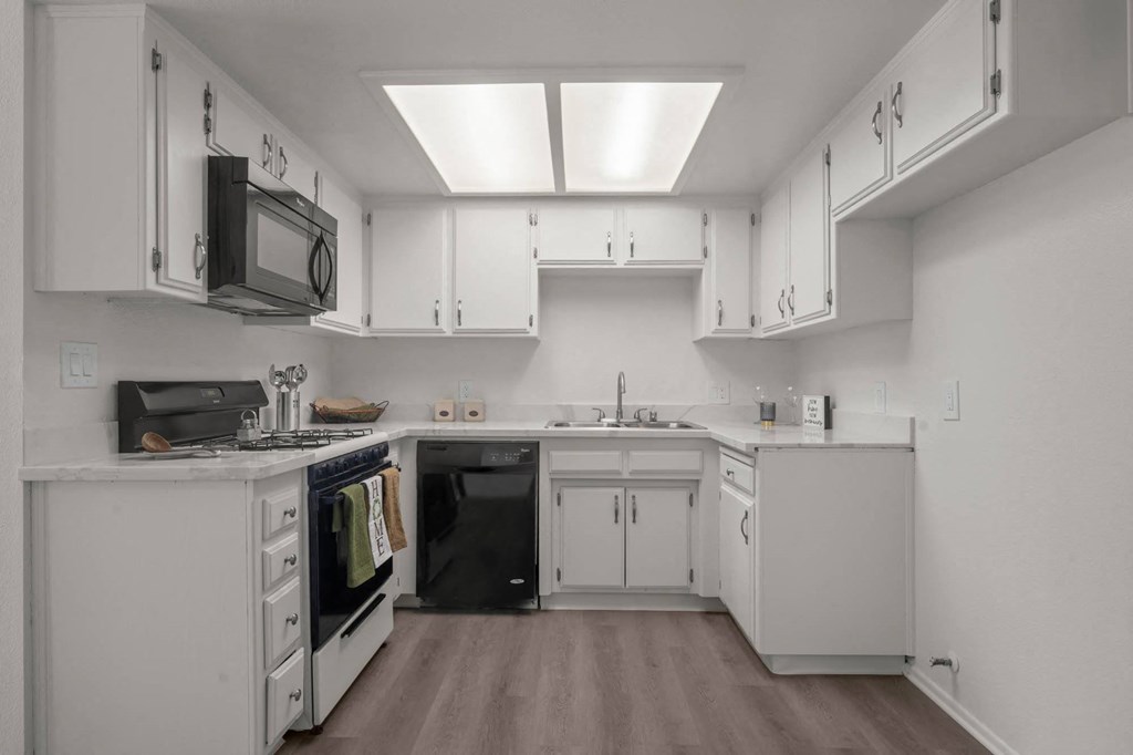 a kitchen with white cabinets and a stove and a microwave