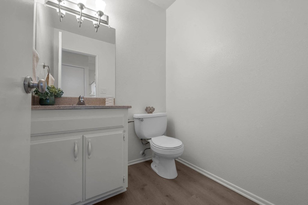 a white bathroom with a toilet and a sink