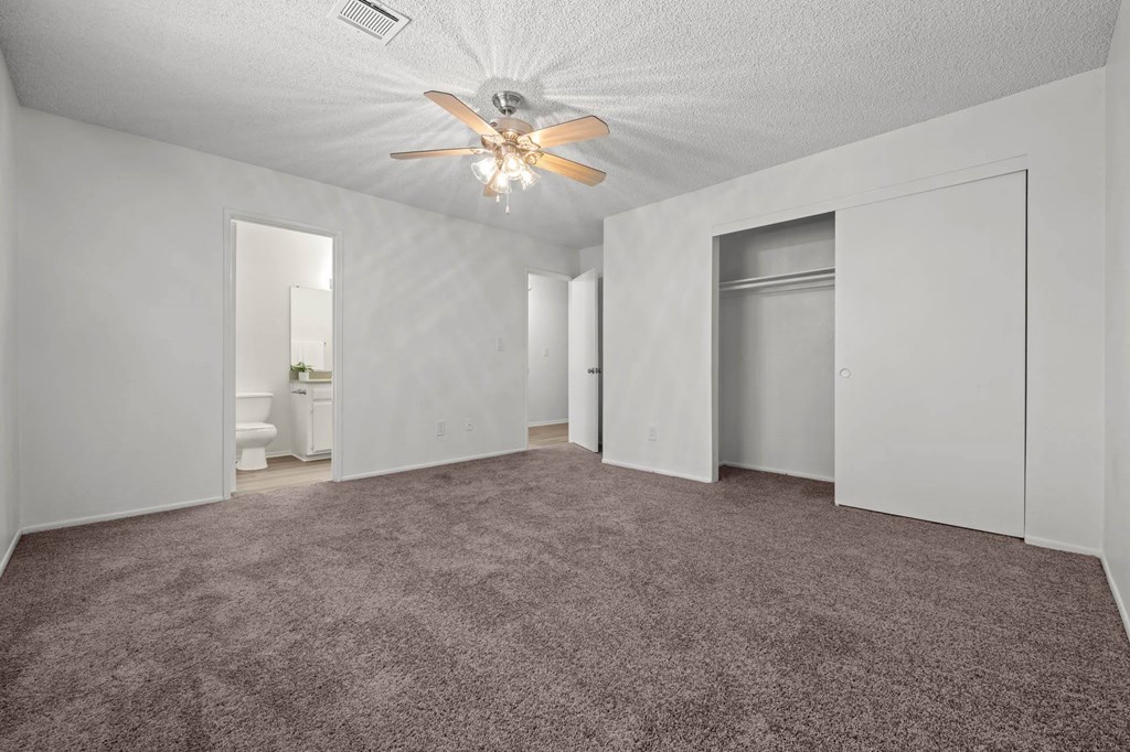 a living room with carpet and a ceiling fan