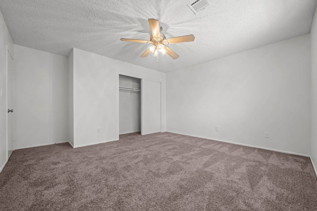 a living room with carpet and a ceiling fan