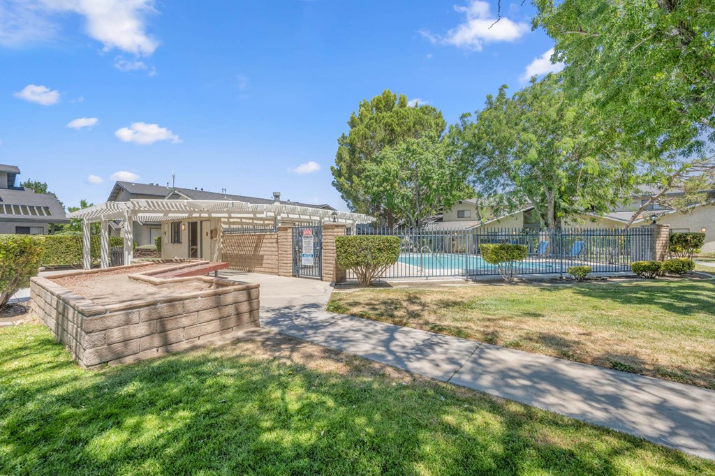 a backyard with a patio and a house with a pool