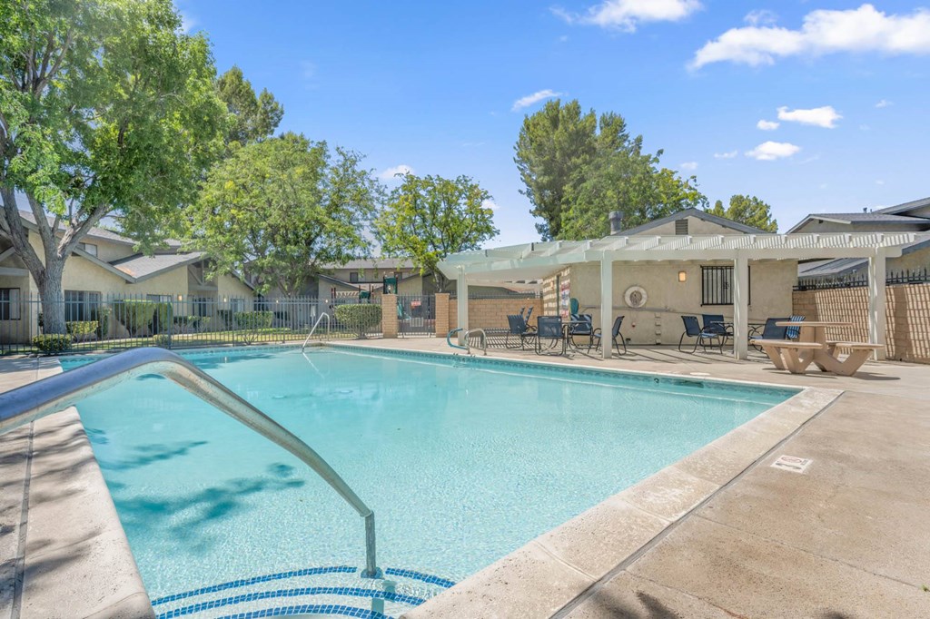 our apartments offer a swimming pool with a patio and trees