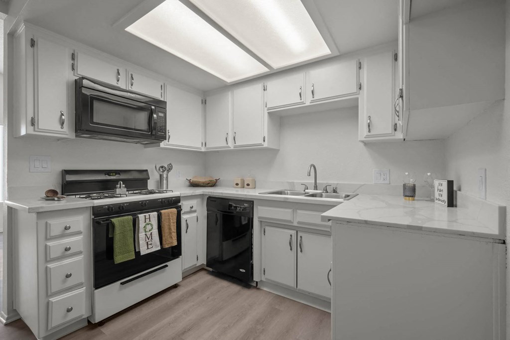 a kitchen with white cabinets and a stove and a microwave