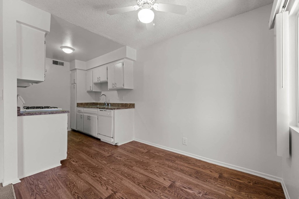 a white kitchen with a wooden floor and white cabinets