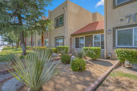 the front of a house with a yard and plants