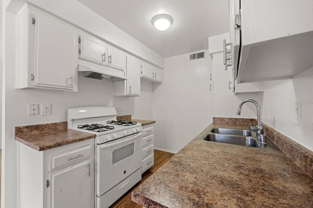 a kitchen with white appliances and granite counter tops