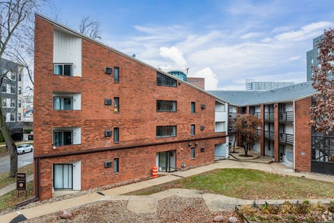 A red brick building with a tree in front of it.
