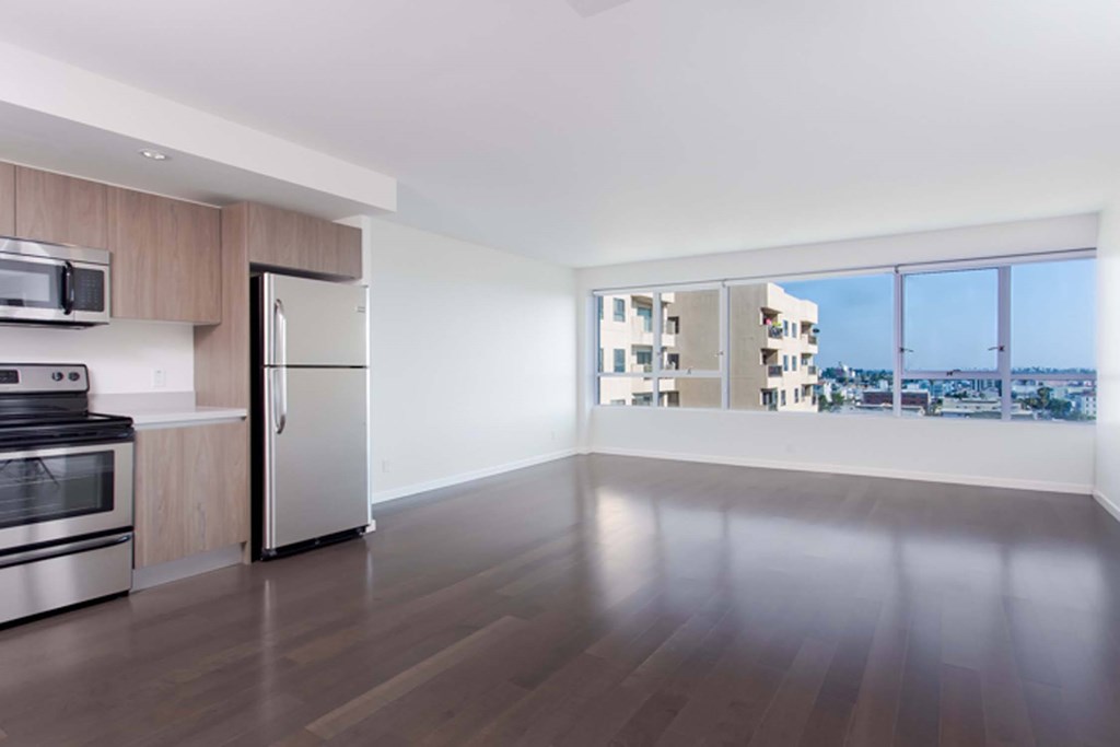 A modern kitchen with a refrigerator, oven, and microwave.