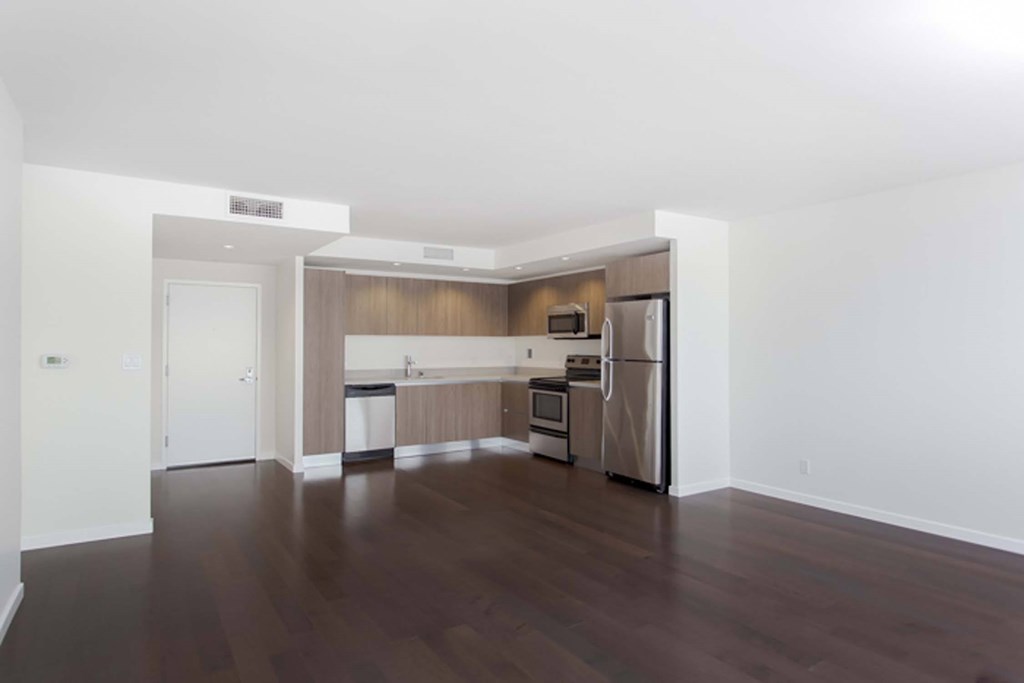 A kitchen with a refrigerator, microwave, and oven is shown in this image.