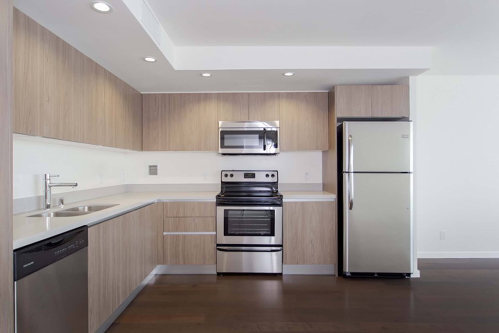 A modern kitchen with a stainless steel refrigerator and oven.