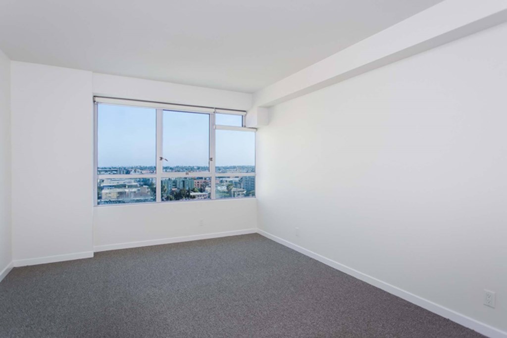 A room with a large window overlooking a cityscape.