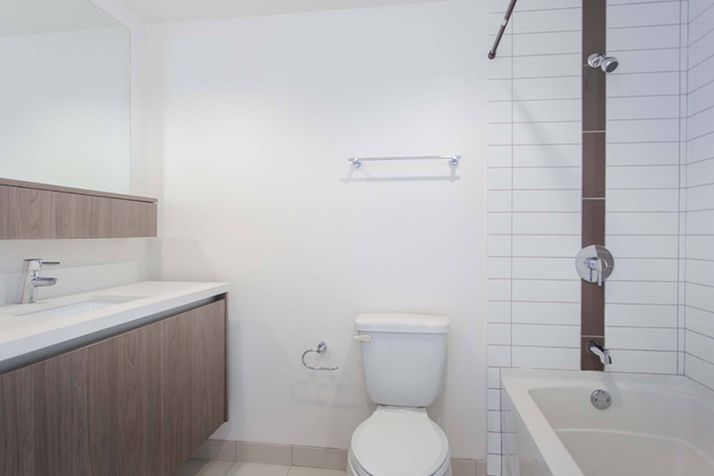 A white toilet sits next to a white sink in a bathroom.
