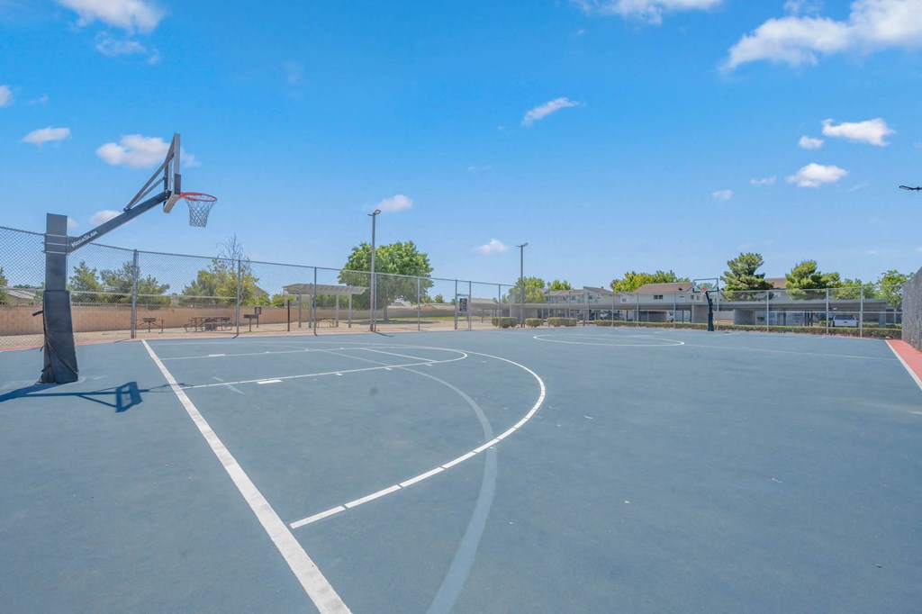 the basketball court is equipped with a basketball hoop and a fence