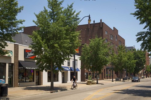 A street scene with a cyclist and a car on the road.