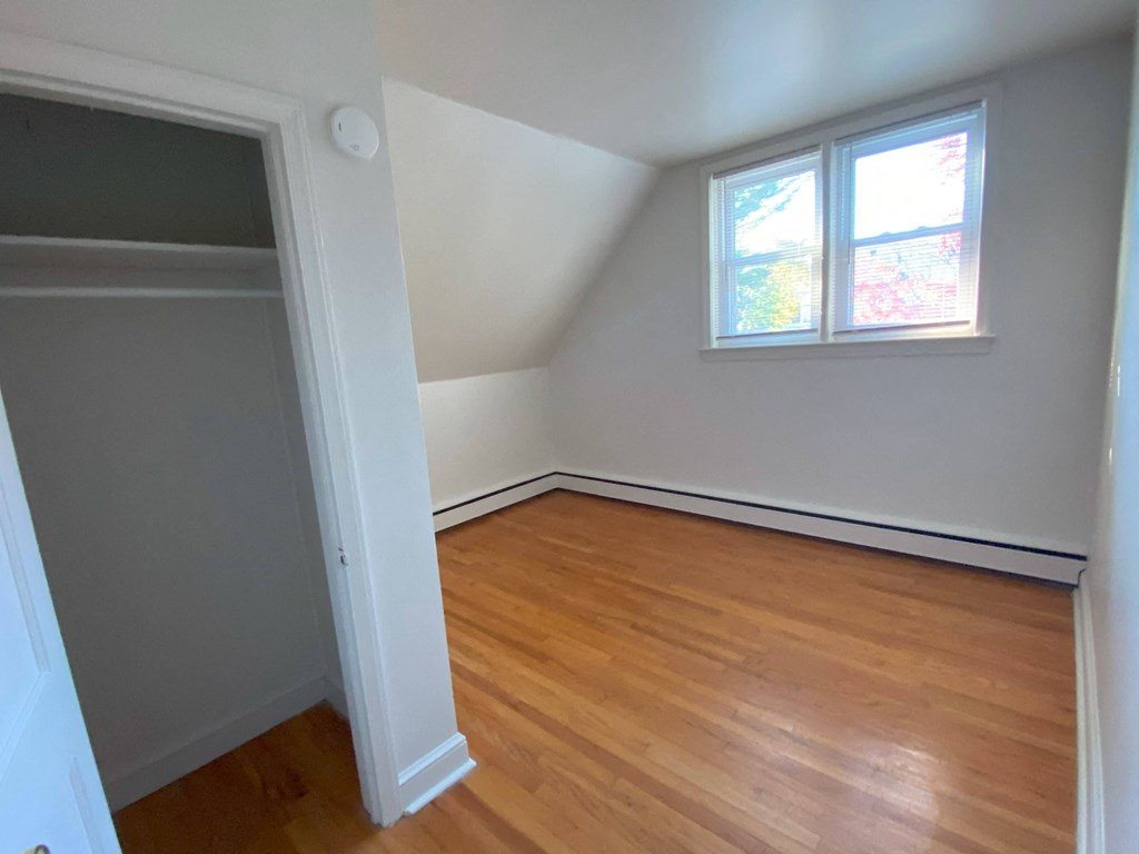 an empty room with a closet and two windows