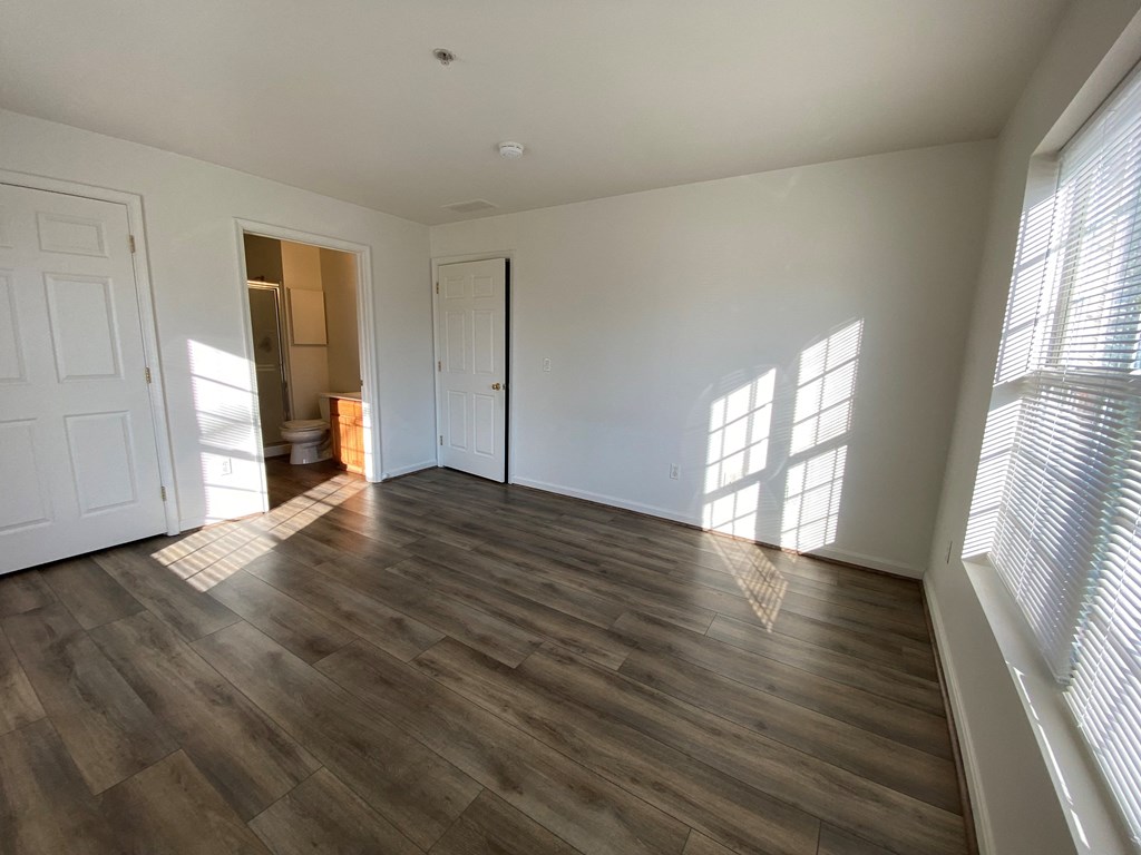 American Square Apartments - 55+ Community - Master Bedroom / Wood-grain vinyl plank flooring