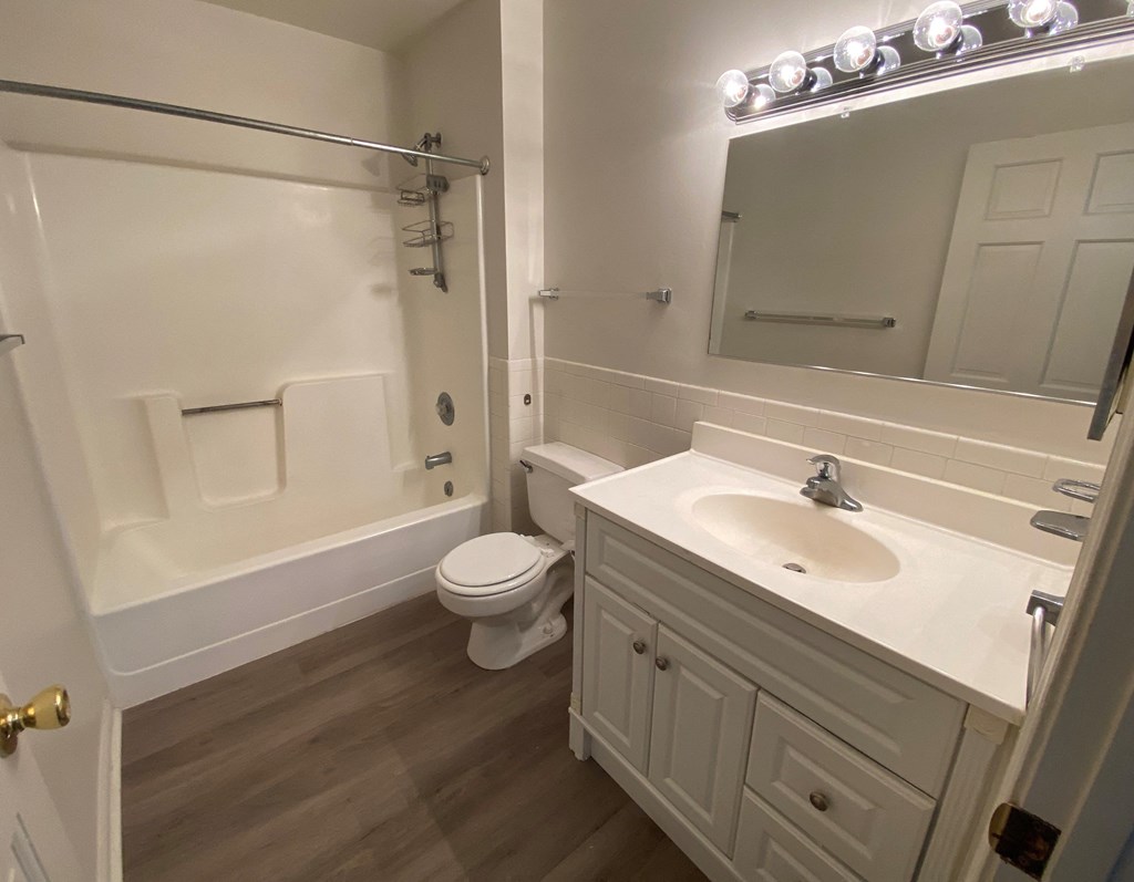 Courtside Apartments - 55+ Community - Bathroom / Bathtub / Vanity / Wood-grain vinyl plank flooring