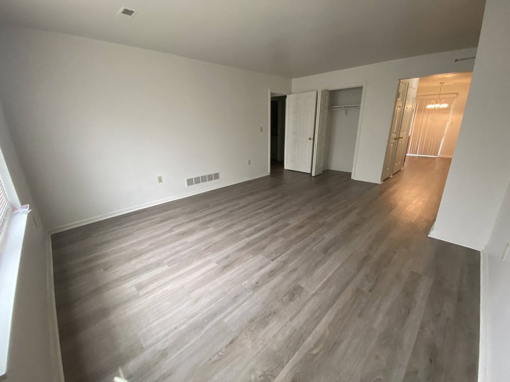 Courtside Apartments - 55+ Community - Living room to Kitchen / Wood-grain vinyl plank flooring