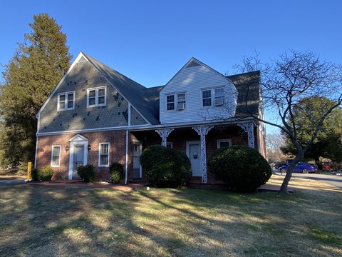 a house with a gray roof and a blue sky in the background