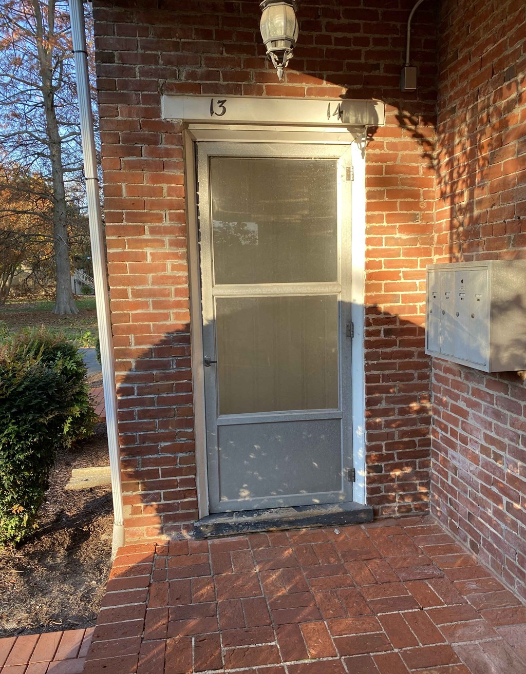 an old door on a brick building with a light above it