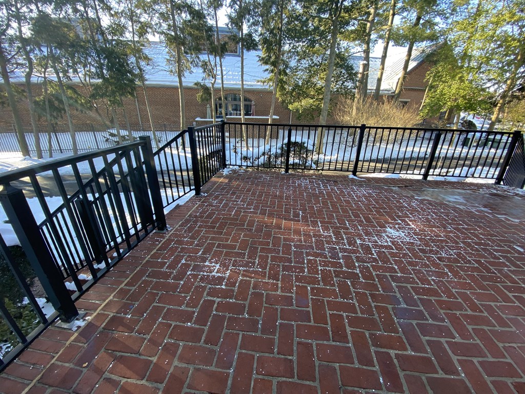 Kings Court Apartments - Front House - Large brick patio with black wrought iron railings