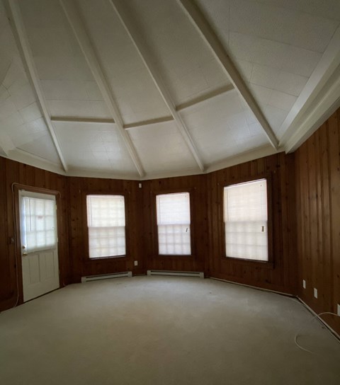 Kings Court Apartments - Front House - Den / Wood-paneled walls / Vaulted, wood-paneled ceiling / Door to brick patio / Wall-to-wall carpet